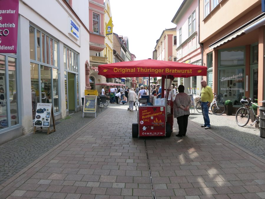 Bratwurststand mit roter Markise in einer Fußgängerzone